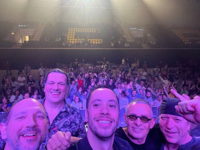 Selfie du groupe devant le public, en salle
